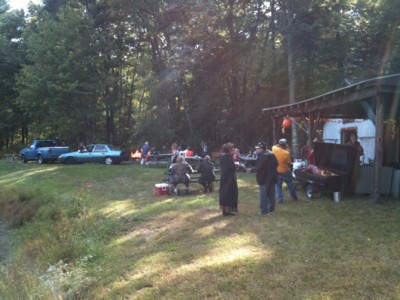 The crowd socializing between the clubhouse and the pond.